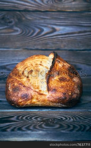 Freshly baked homemade tartine bread on dark wooden table