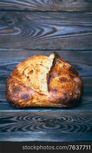 Freshly baked homemade tartine bread on dark wooden table