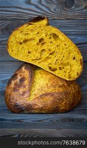 Freshly baked homemade tartine bread with turmeric on dark wooden table