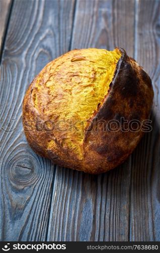 Freshly baked homemade tartine bread with turmeric on dark wooden table