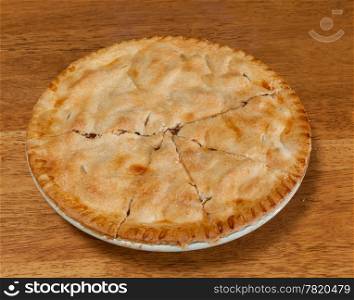 Freshly baked hot apple pie on wooden table