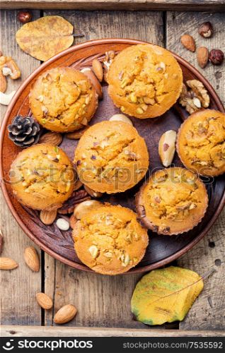 Freshly baked pumpkin muffins with nut.Autumn dessert in an old wooden tray. Autumn pumpkin muffins