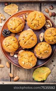 Freshly baked pumpkin muffins with nut.Autumn dessert in an old wooden tray. Autumn pumpkin muffins