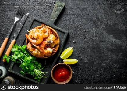 Freshly cooked shrimps with parsley. On black rustic background. Freshly cooked shrimps with parsley.