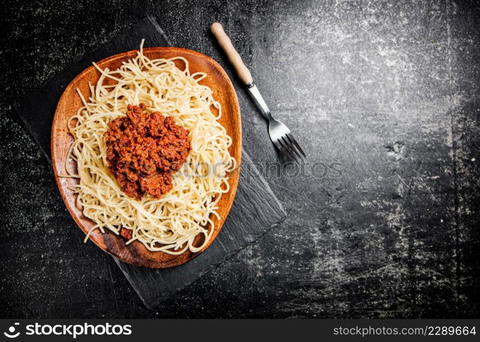 Freshly cooked spaghetti bolognese. On a black background. High quality photo. Freshly cooked spaghetti bolognese. On a black background.