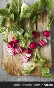 Freshly harvested, purple colorful radish on wooden cutting board. Growing radish. Growing vegetables. Seasonal Cooking, food styling. European red radishes (Raphanus sativus). raw foods concept