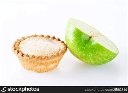 Freshly made apple pie and half of apple over white background