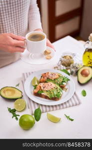 Freshly made Avocado, salmon and cream cheese toasts on a white ceramic plate.. Freshly made Avocado, salmon and cream cheese toasts on a white ceramic plate