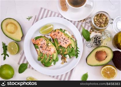 Freshly made Avocado, salmon and cream cheese toasts on a white ceramic plate.. Freshly made Avocado, salmon and cream cheese toasts on a white ceramic plate