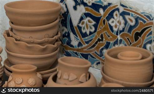freshly made clay pots on a decorative mosaic background. children&rsquo;s crafts. clay art pots