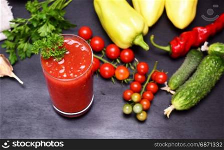 Freshly made juice of tomato and spices in a glass beaker, top view, selective focus