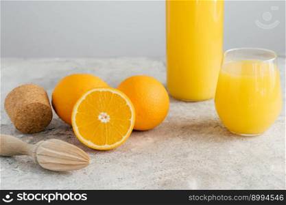 Freshly made orange juice containing vitamin C, sliced oranges, wooden cork and squeezer. Process of making fruit drink. Healthy beverage