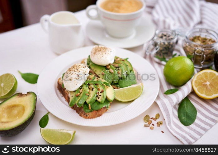 Freshly made poached egg and Avocado toasts on light grey background.. Freshly made poached egg and Avocado toasts on light grey background