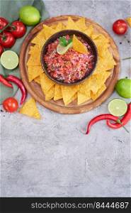 freshly made salsa dip sauce with nacho chips on wooden board.. freshly made salsa dip sauce with nacho chips on wooden board