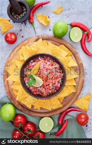 freshly made salsa dip sauce with nacho chips on wooden board.. freshly made salsa dip sauce with nacho chips on wooden board