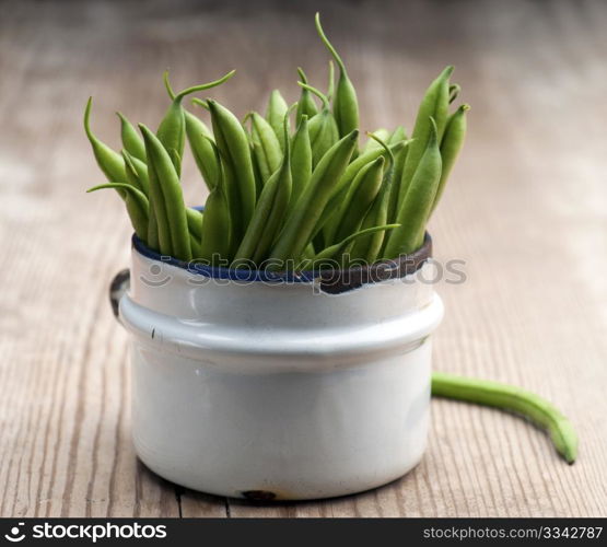 Freshly Picked Green Beans In An Old Enamel Mug On A Wooden Surface