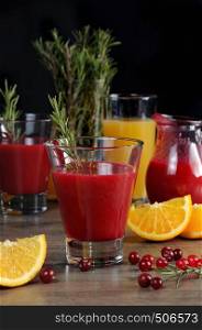 Freshly prepared cranberry fruit-drink with orange juice and a sprig of rosemary
