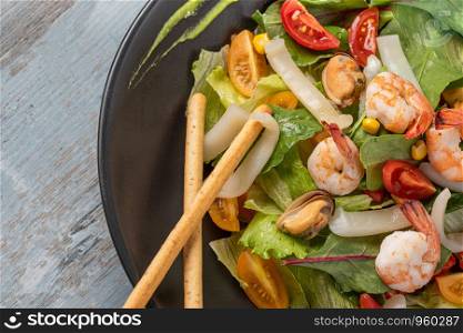 Freshly prepared Seafood salad bowl on wooden background. Fresh Seafood salad