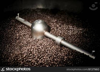 Freshly roasted coffee beans in a coffee roaster.Frozen moment. 