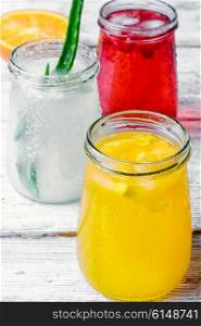Freshly squeezed orange juice and citrus fruit in stylish glass jars. refreshing juice from fruits and aloe