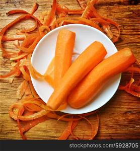 Freshly washed carrots in white dish on wooden background