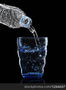 freshness cool and clean drinking water pouring to blue glass isolated on black background use for healthy care food and drink beverage
