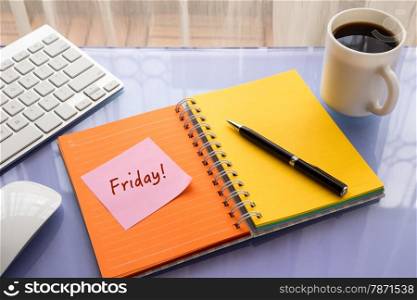 Friday word on note pad stick on blank colorful paper notebook at workspace