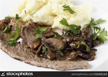 Fried and peppered escalope of veal served with mashed potatoes and a creamy sauteed mushroom sauce
