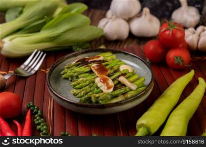 Fried asparagus with oyster sauce in a plate with bell peppers Fresh pepper and tomato.