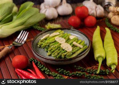 Fried asparagus with oyster sauce in a plate with bell peppers Fresh pepper and tomato.