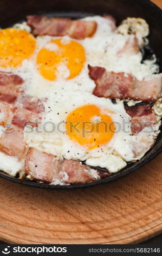 Fried bacon and eggs on the pan - rusty breakfast