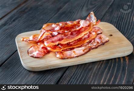 Fried bacon on the cutting board, rustic background