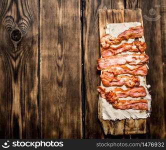 Fried bacon on the fabric. On a wooden table.. Fried bacon on the fabric.