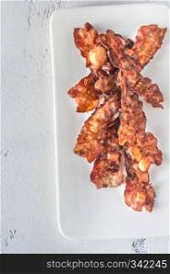 Fried bacon strips on the white plate