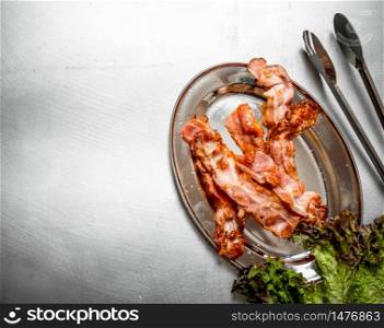 Fried bacon with greens. On the Metal table.. Fried bacon with greens. On Metal table.