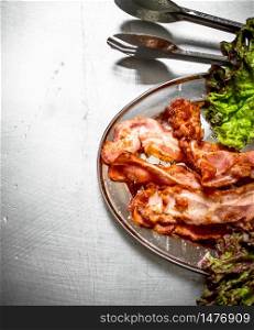 Fried bacon with greens. On the Metal table.. Fried bacon with greens. On Metal table.