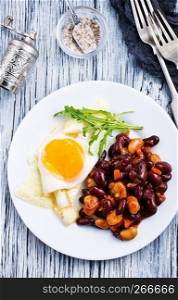 fried bean with fried eggs on plate for breakfast