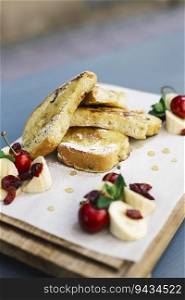 Fried bread with sugar with decoration of chopped banana and cherries for breakfast
