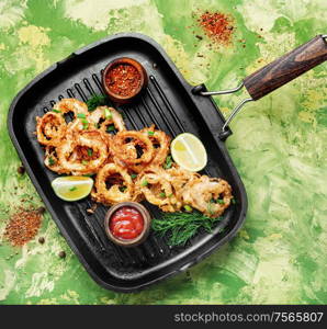 Fried calamari rings with sauce.Fast food.Fried rings of squid in the frying pan. Crispy fried squid rings