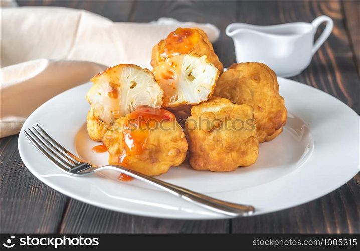 Fried cauliflower coated in batter with spicy sauce