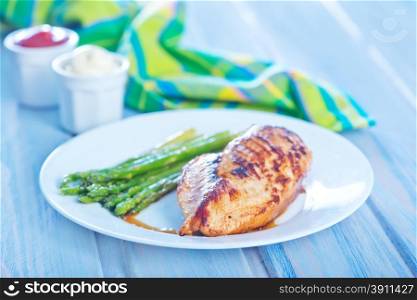 fried chicken and asparagus on the white plate