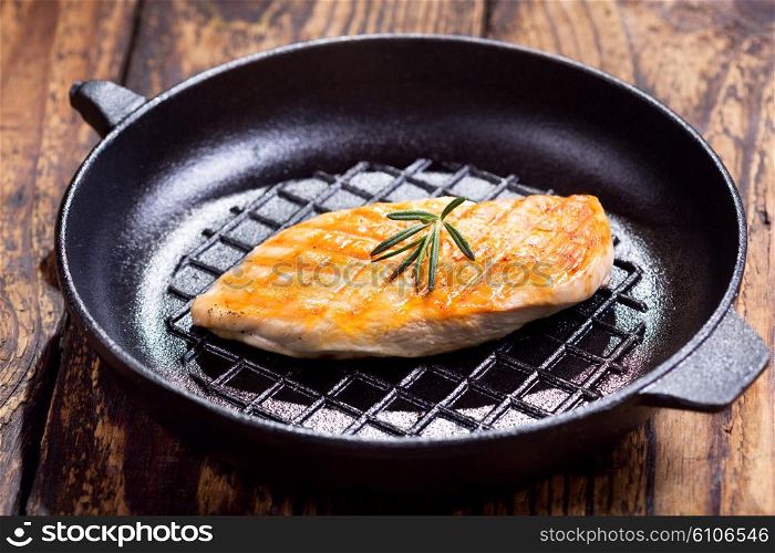 fried chicken breast with rosemary in a pan