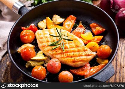fried chicken breast with vegetables in a pan