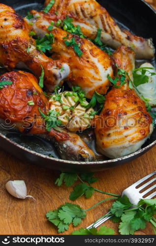 fried chicken drumsticks in a frying pan on wooden table