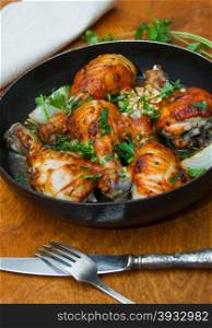 fried chicken drumsticks in a frying pan on wooden table