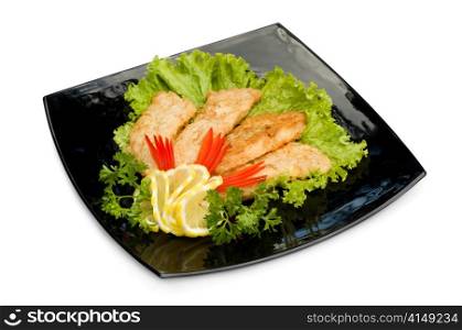 fried chicken fillet with fresh vegetables, on black square plate, isolated. fried chicken fillet with vegetables