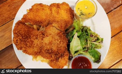 Fried chicken fillets and potato French Fries and salad