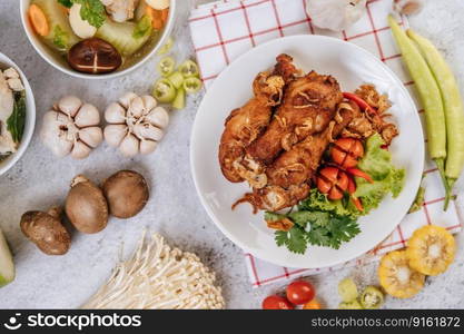 Fried chicken leg with tomato, chili, fried onion, lettuce, corn, and needle mushroom.