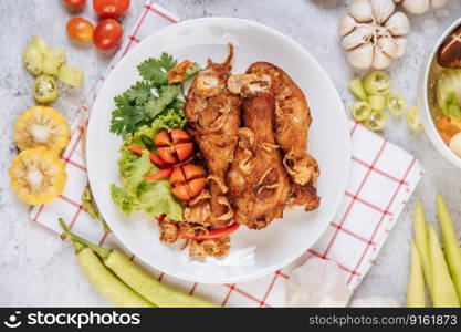 Fried chicken leg with tomato, chili, fried onion, lettuce, corn, and needle mushroom.