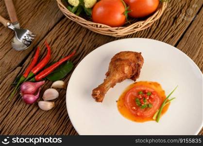 Fried chicken legs on a white plate with sauce.
